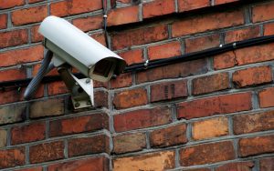 caméra de surveillance sur un mur en briques rouges