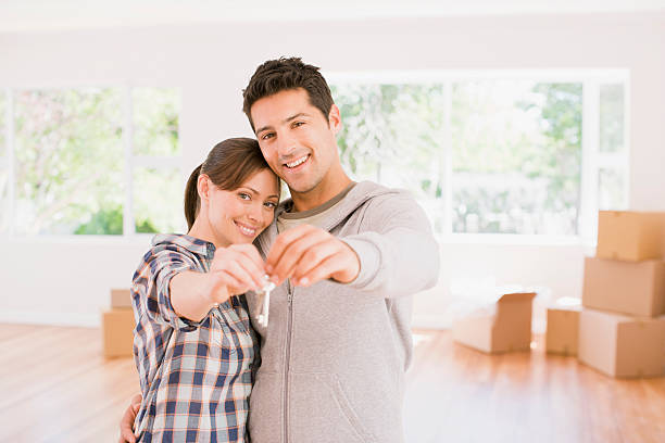 Couple qui tient les clés de la maison qu'il vient d'acheter